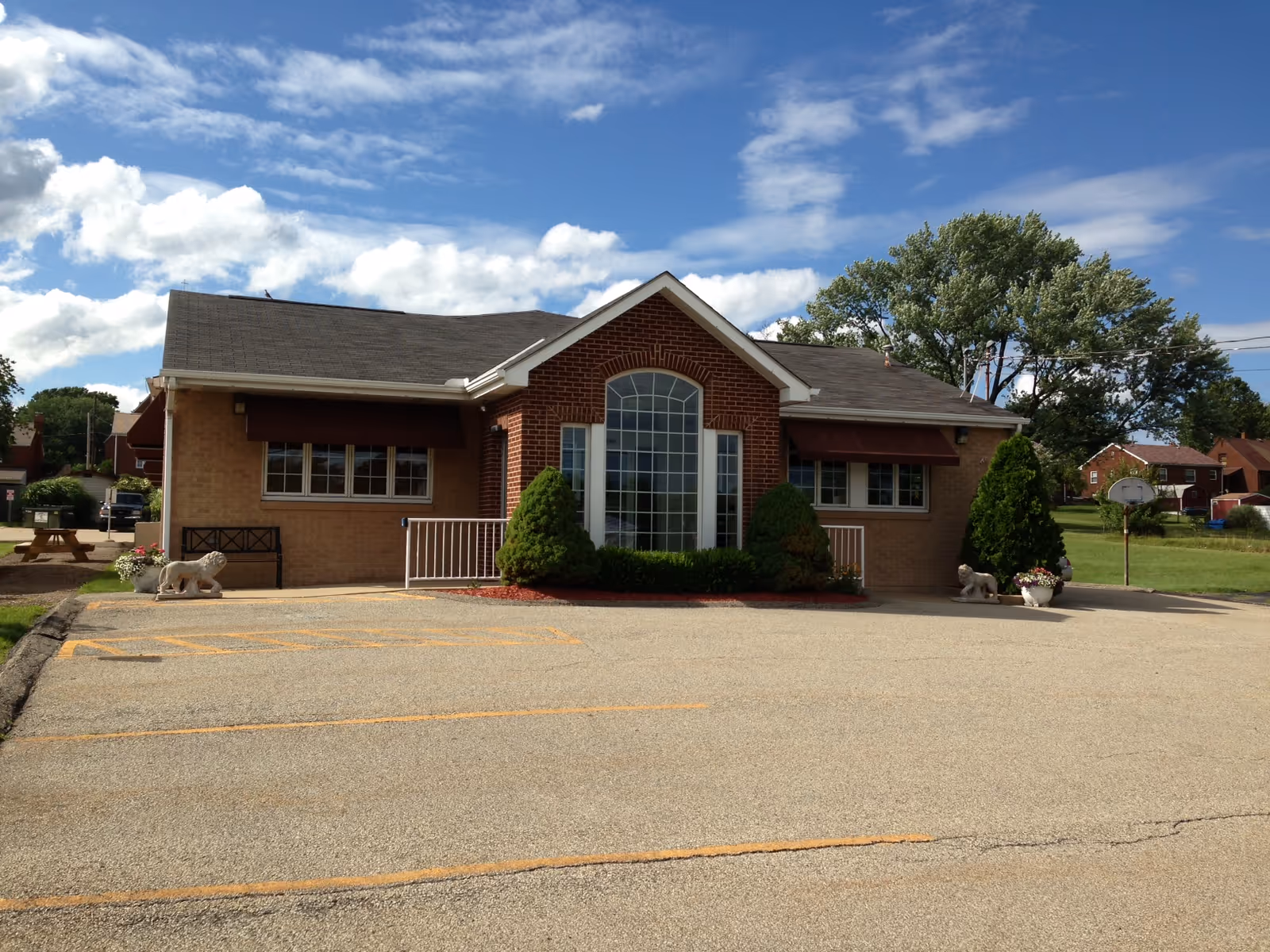 Westarm Home Health brick building front with arched window and shrubs