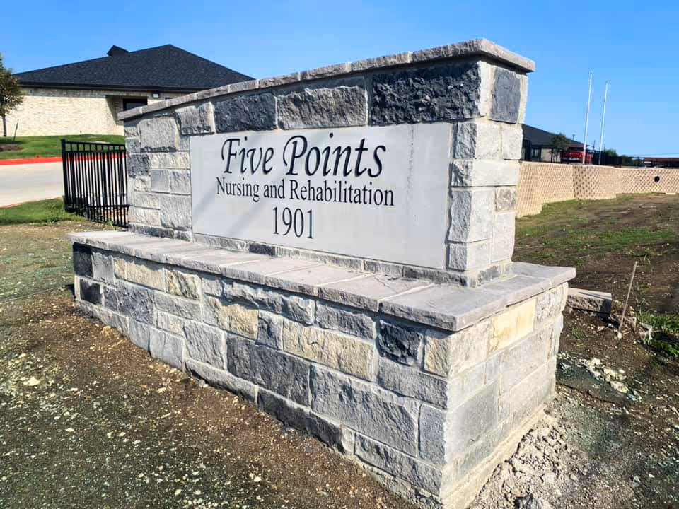 Stone entrance sign reading Five Points Nursing and Rehabilitation 1901 at the facility.