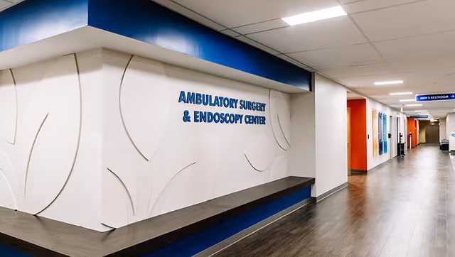 Interior hospital corridor with an ambulatory surgery and endoscopy center sign along a bright hallway.
