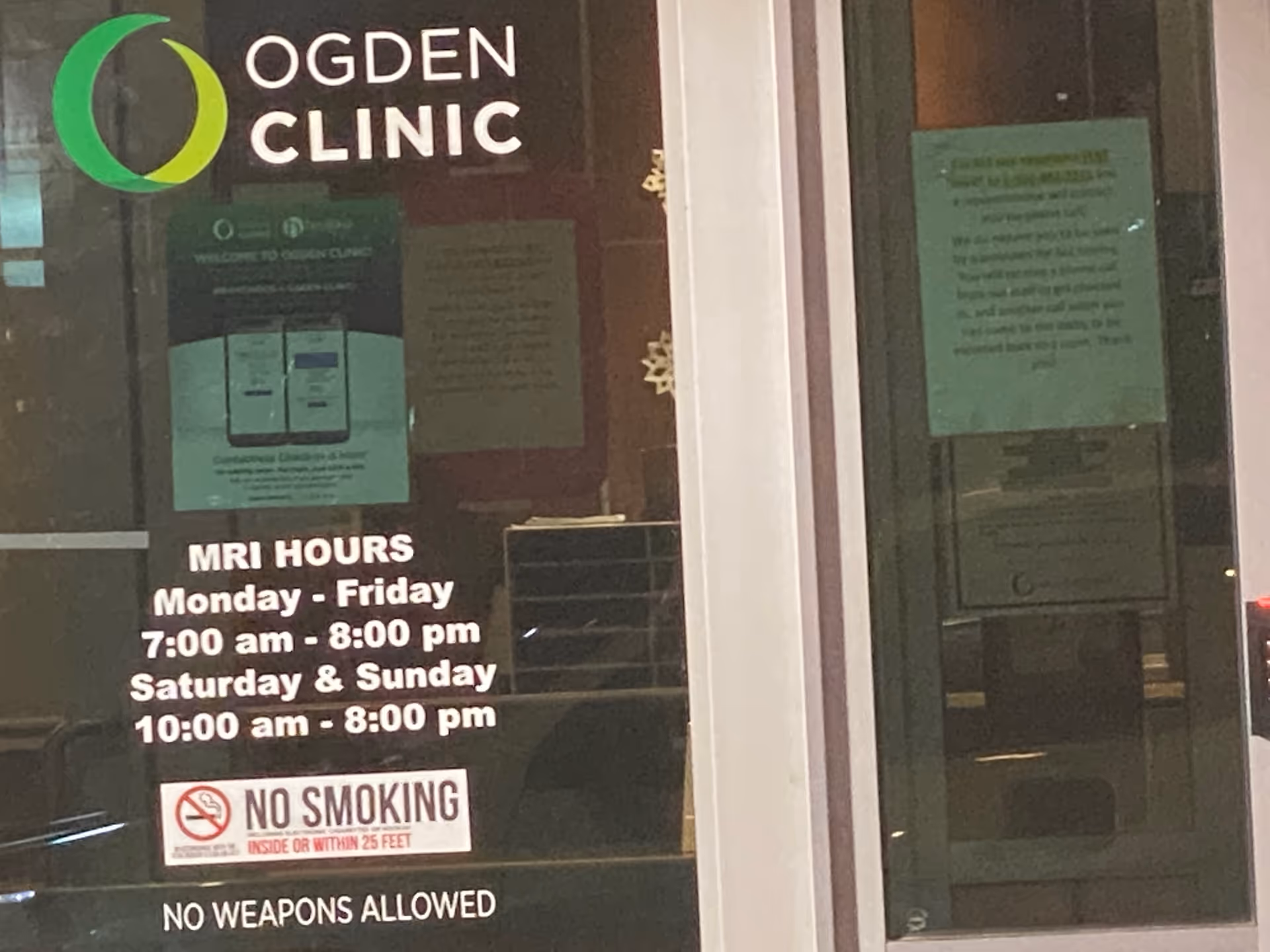 Ogden Clinic front entrance with glass doors and posted MRI hours and notices.