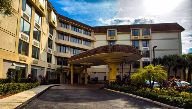 Exterior view of The Atrium at Boca Raton with a covered entrance and landscaped driveway.