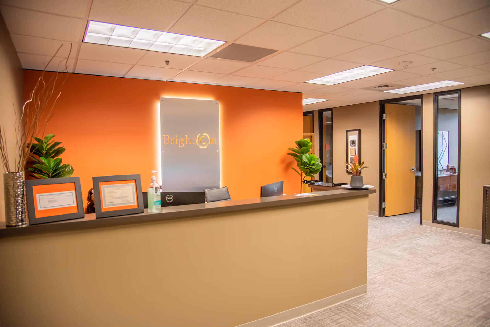 Reception desk in a bright orange-walled lobby at Brighton Hospice Eugene.