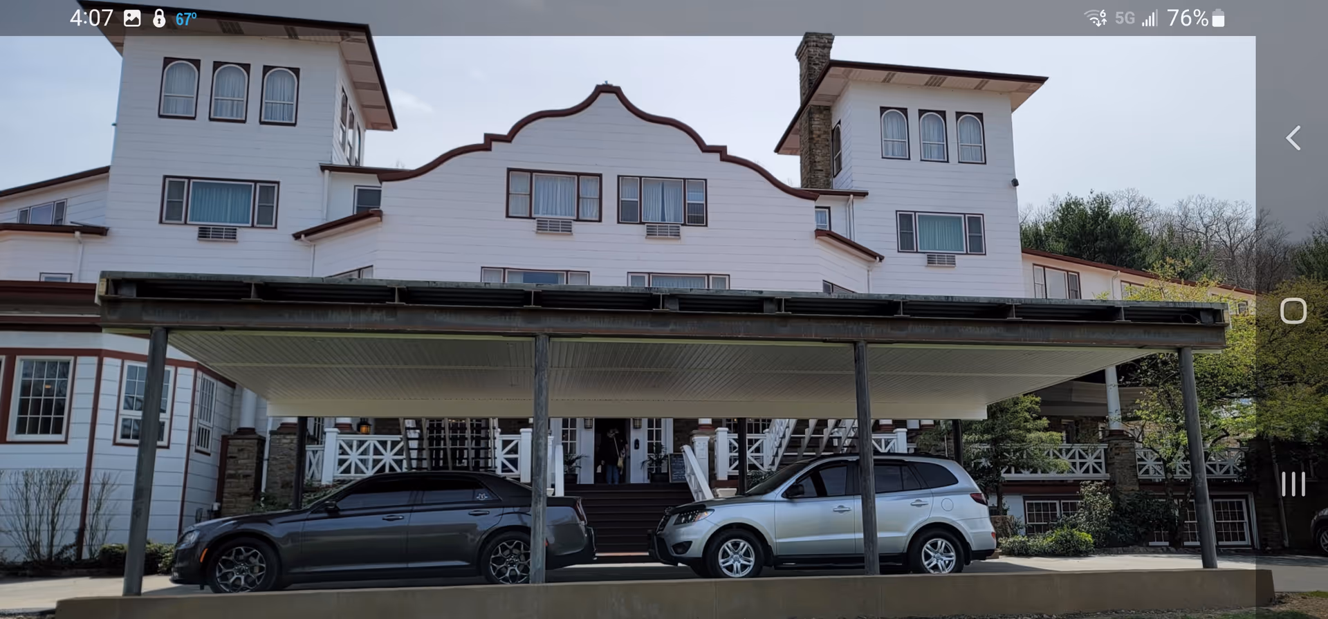 White multi-story senior facility with decorative front facade and a covered carport at entrance.
