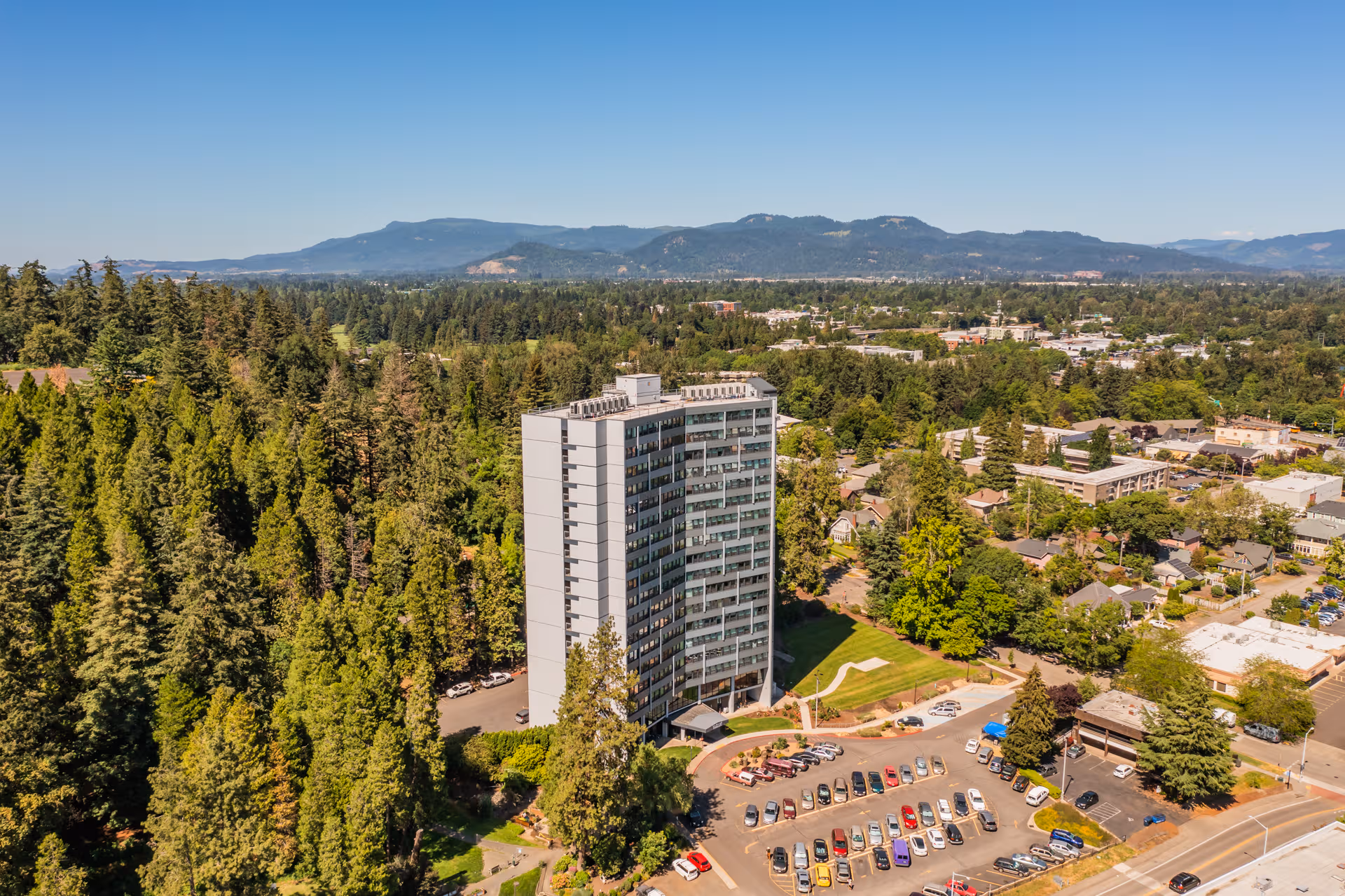 Ya-Po-Ah Terrace exterior: tall building amid trees with a large parking lot.