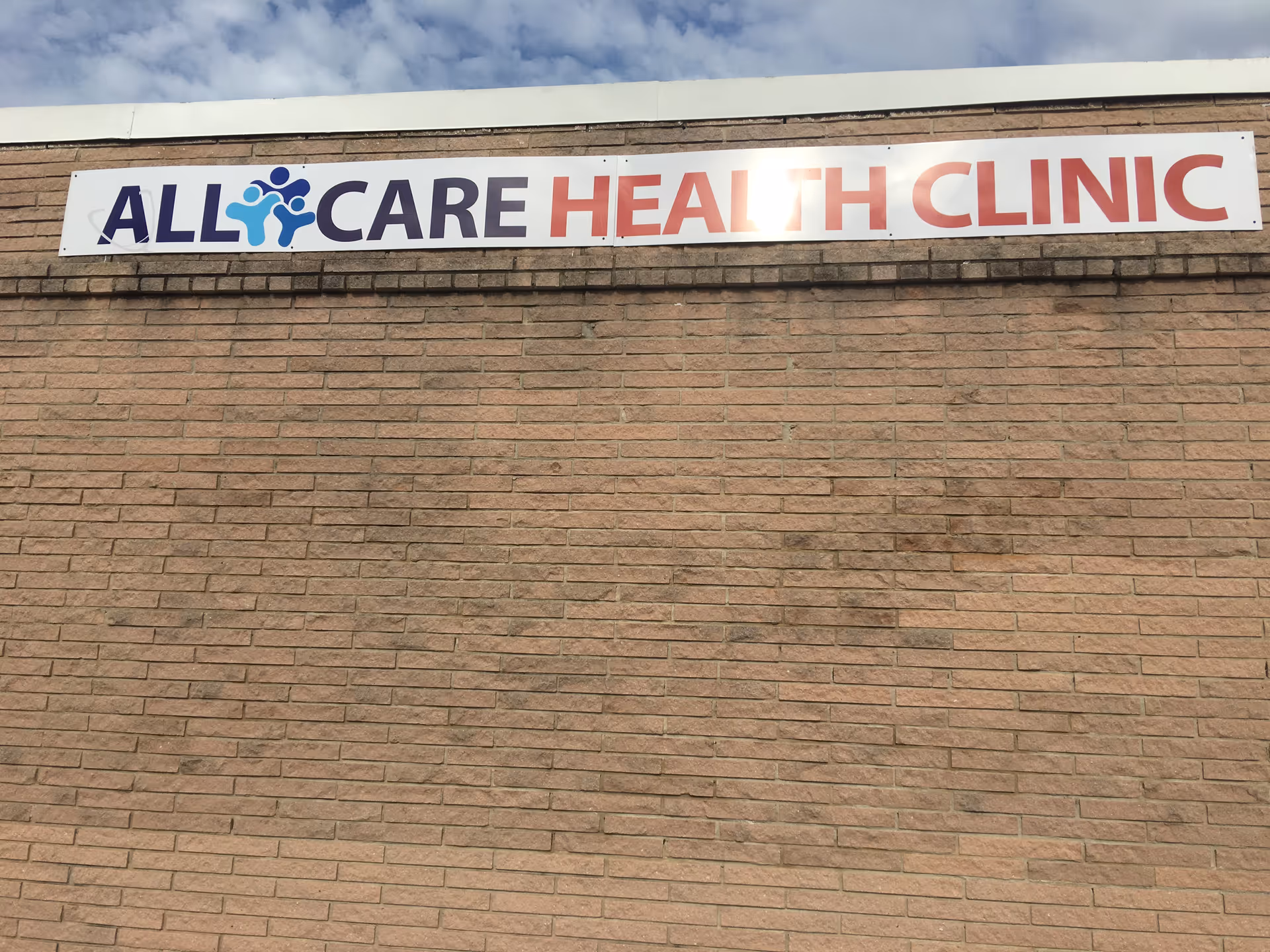 Brick exterior with a sign reading All Care Health Clinic.