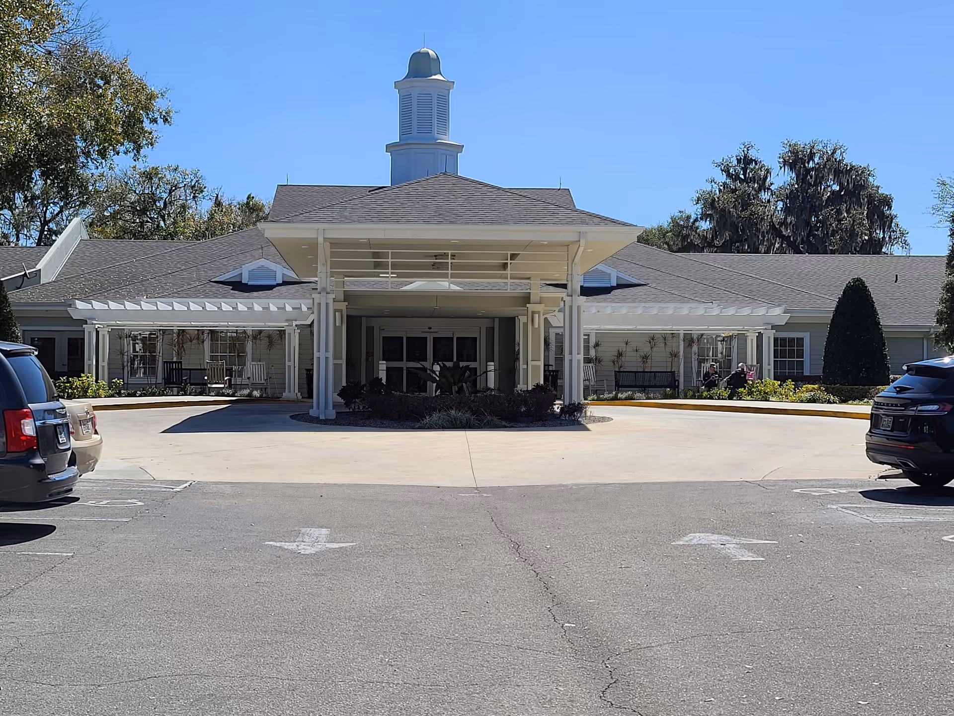 Front view of Apopka Health and Rehabilitation Center entrance with porte-cochère and cars.