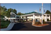 Exterior view of Hanover Hill Health Care Center entrance with driveway and flagpole.