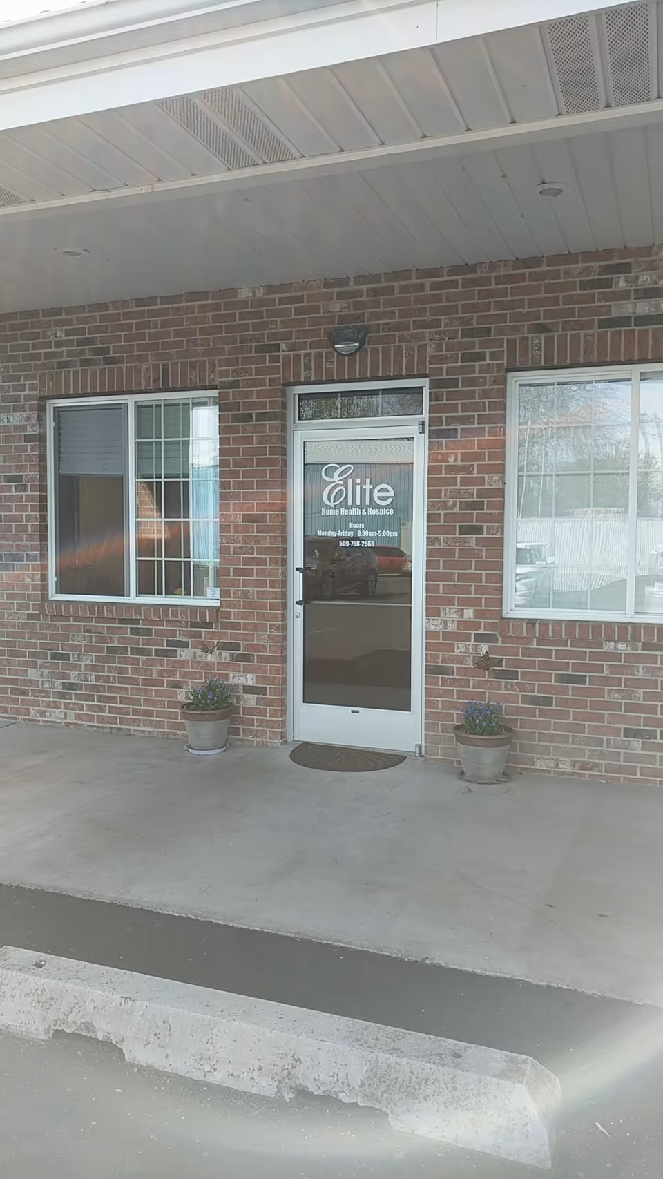 Brick building exterior with Elite Home Health & Hospice entrance under a covered walkway.