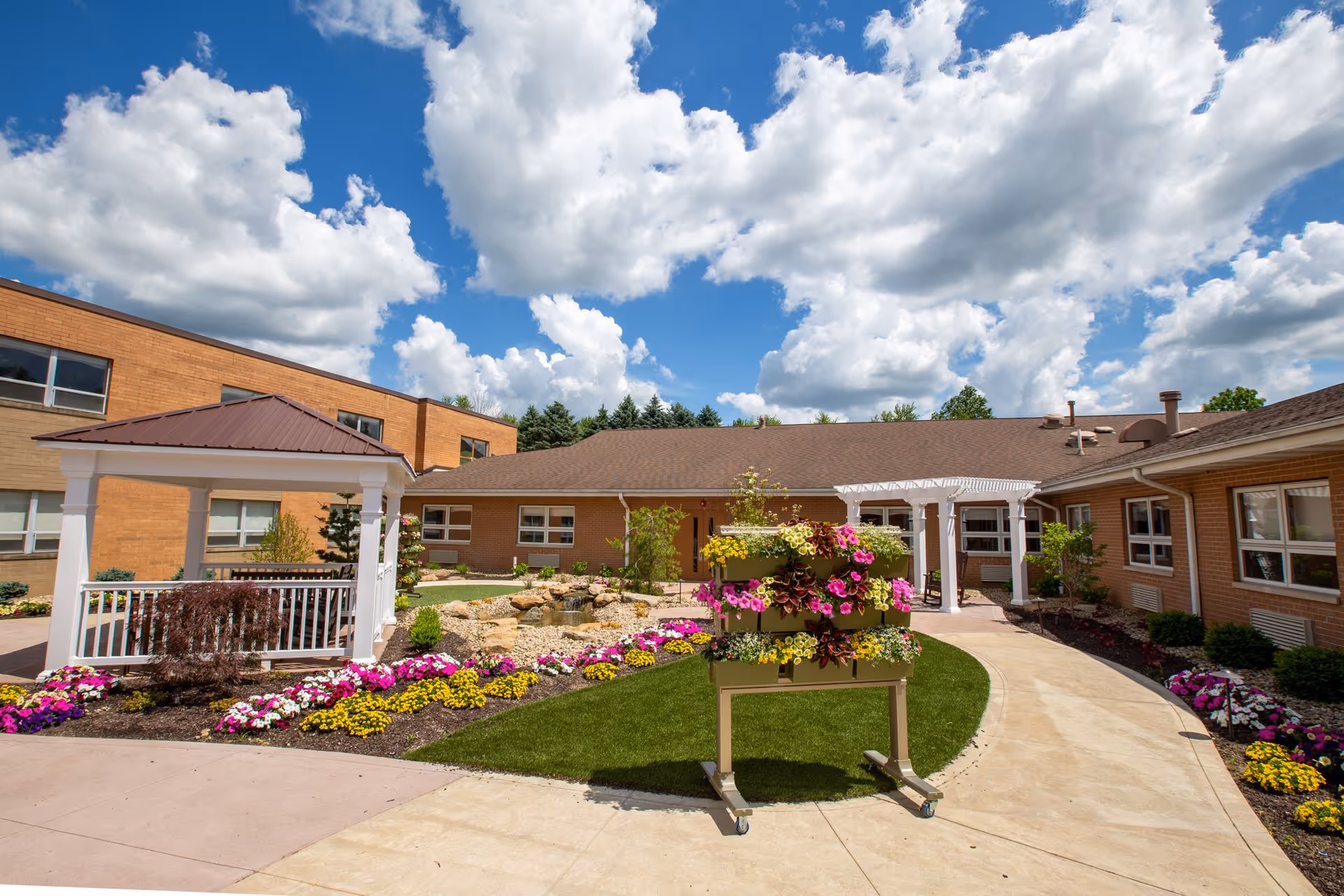 Senior living facility outdoor courtyard with brick buildings and colorful flowers