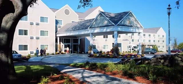Exterior view of Brookdale Sakonnet Bay with a covered entrance and landscaped walkway.