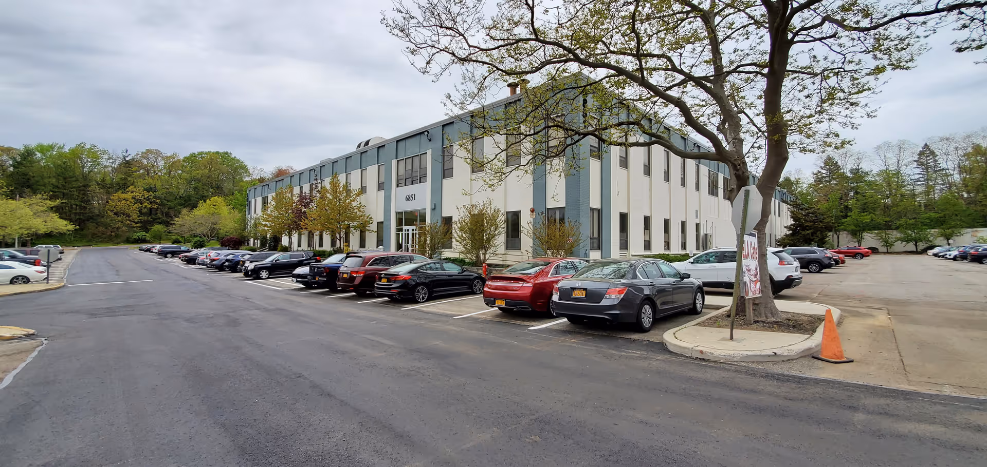 Exterior view of a Constellation Health Services building with a parking lot and trees.