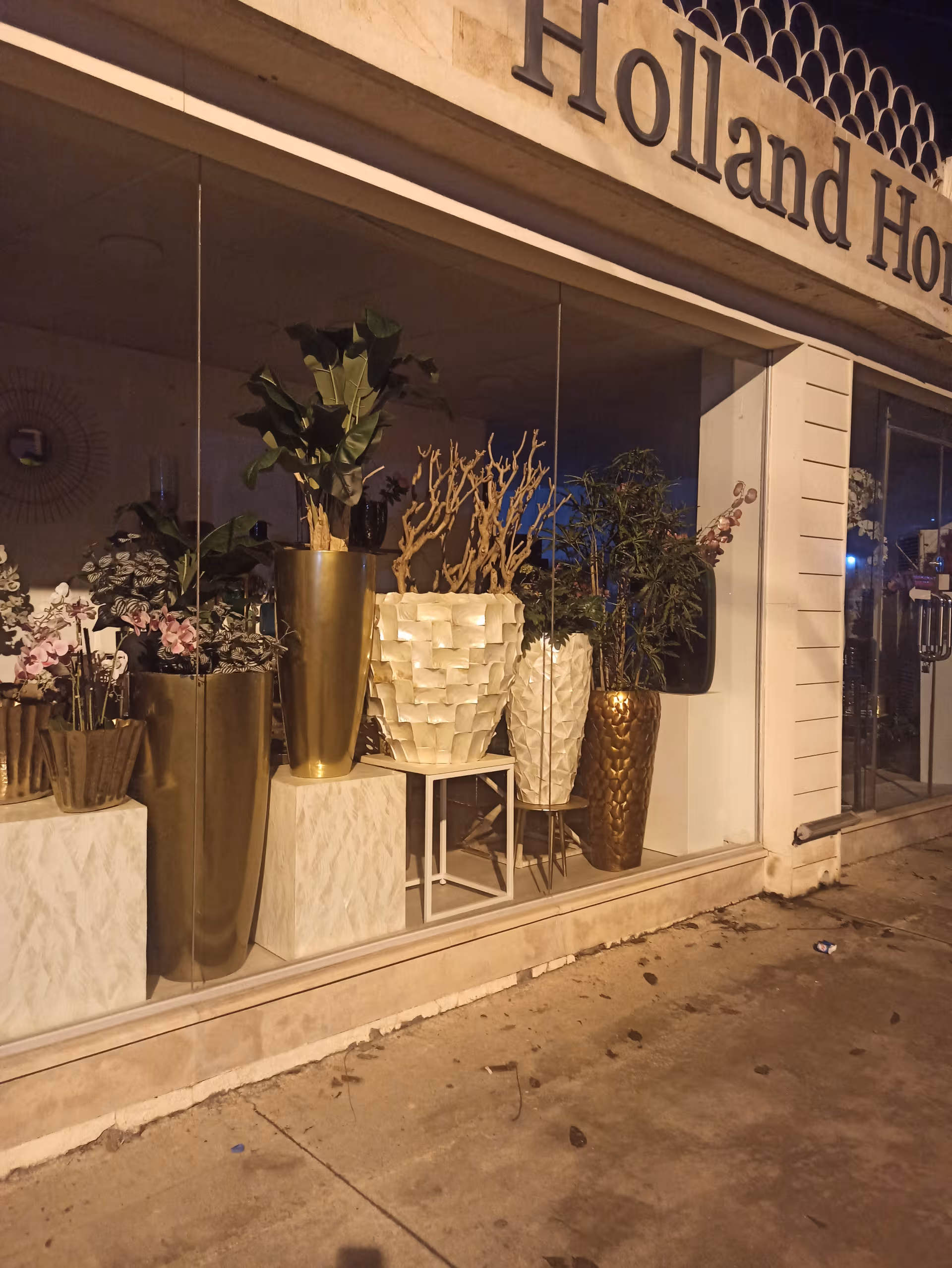 Storefront window display at Holland Home Raybrook Campus featuring tall decorative planters.