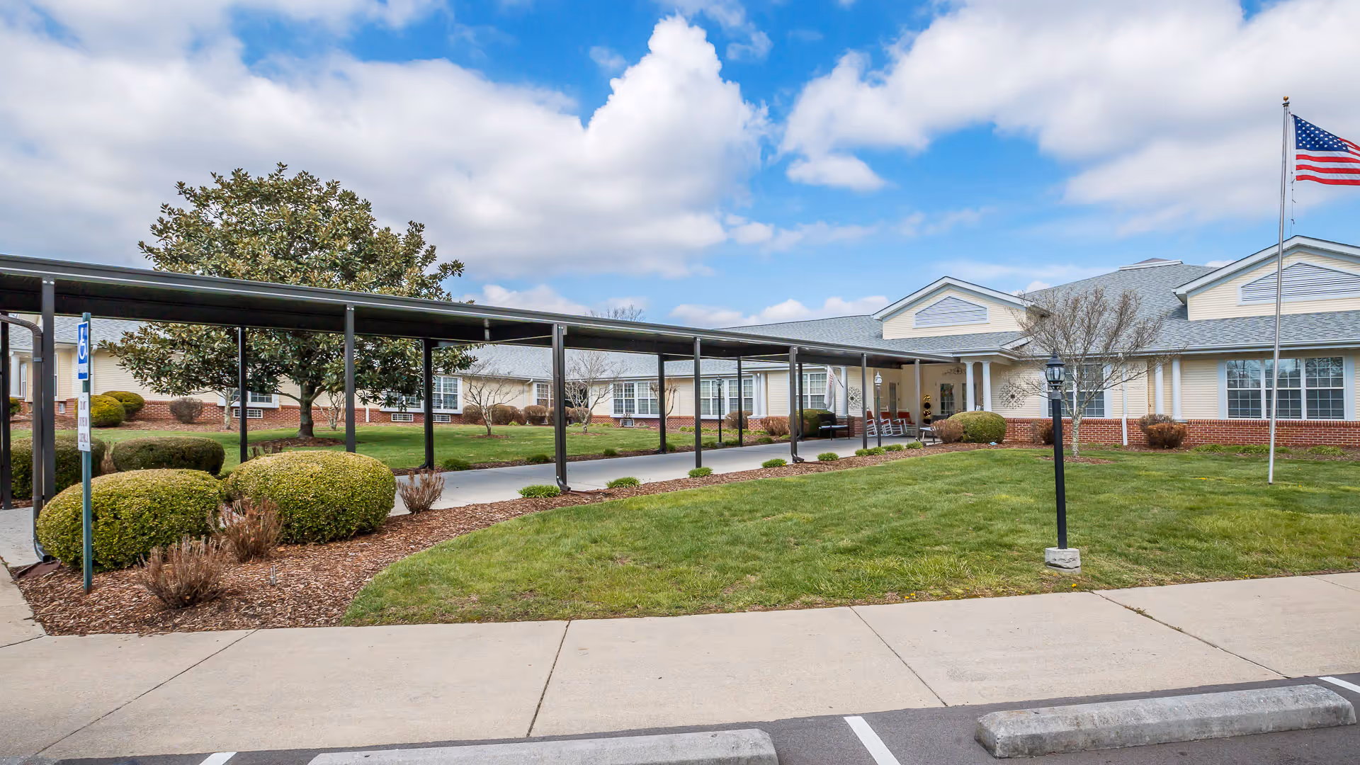 Single-story senior living facility with a covered walkway and manicured lawn