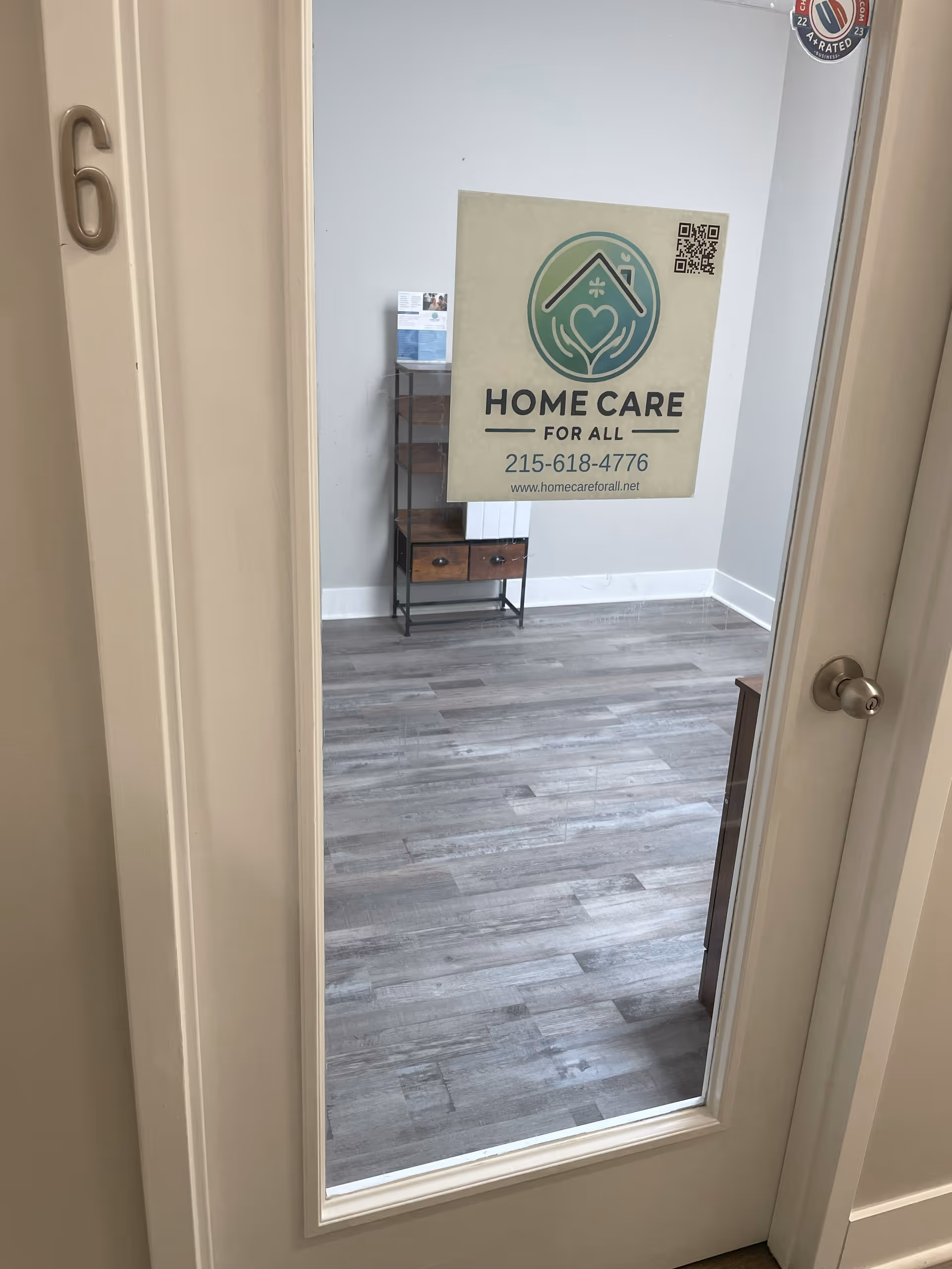 Interior hallway with a Home Care for All sign on a glass door.