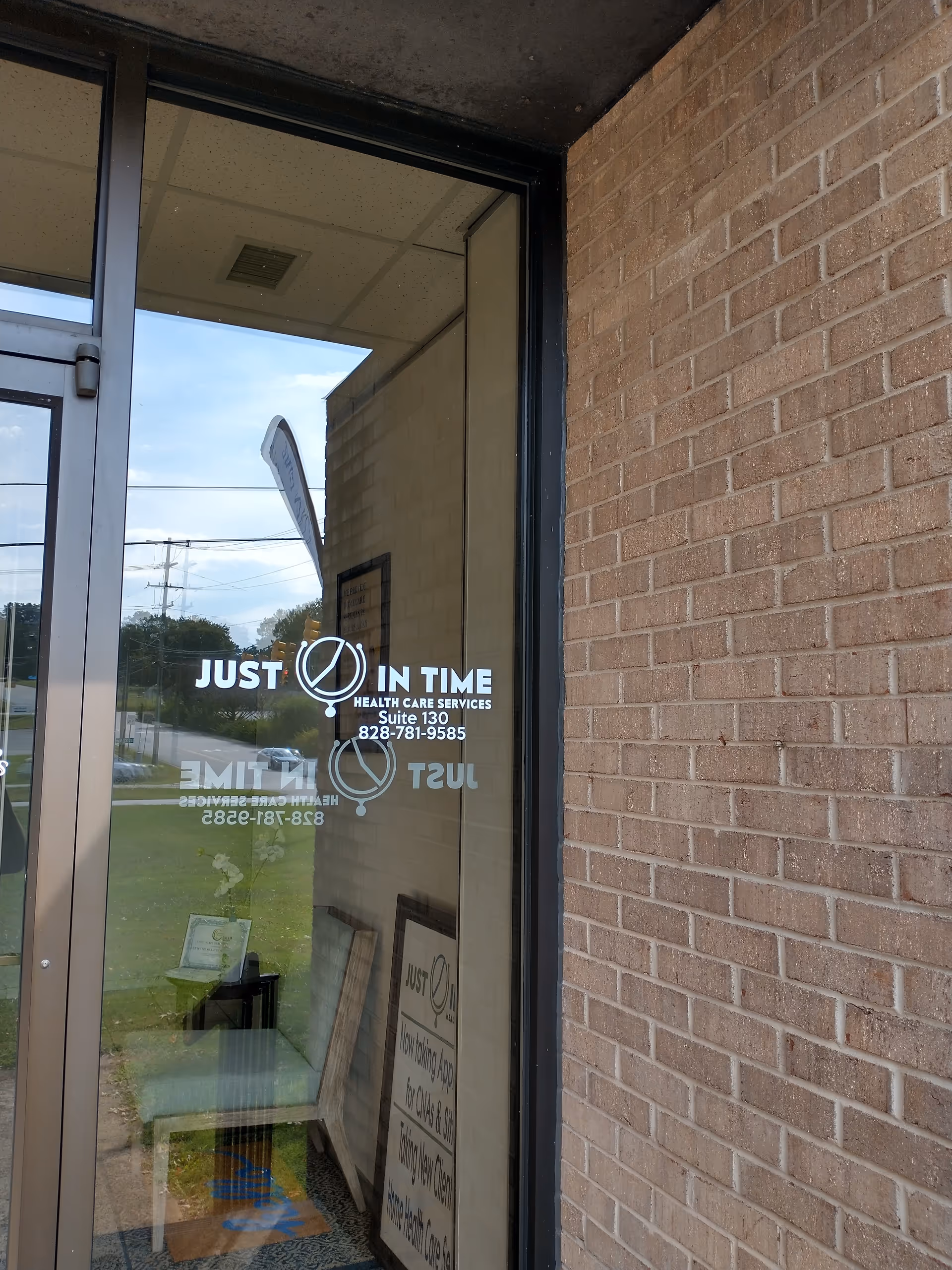 Glass entrance door displaying Just In Time Health Care Services logo on brick exterior.