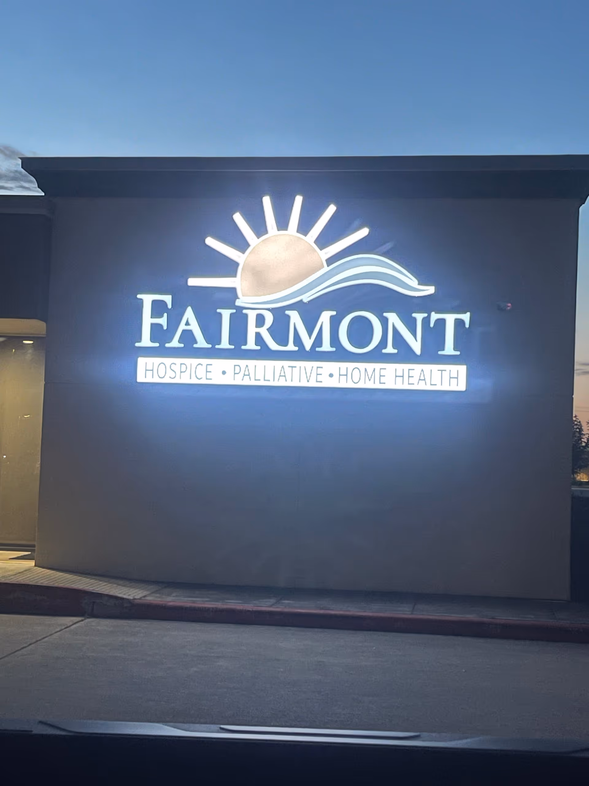 Exterior view of a building with a large illuminated Fairmont Hospice sign.
