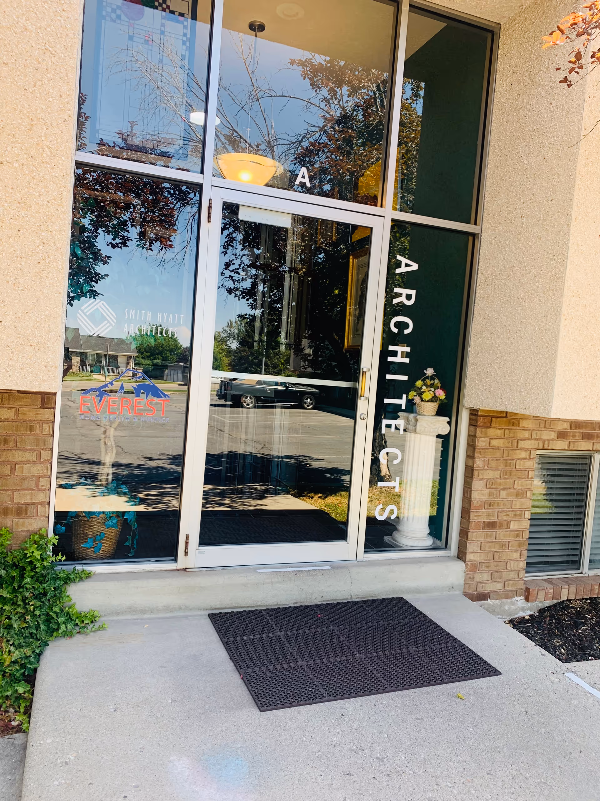 Exterior glass doorway of Everest facility showing Everest logo and vertical ARCHITECTS sign.