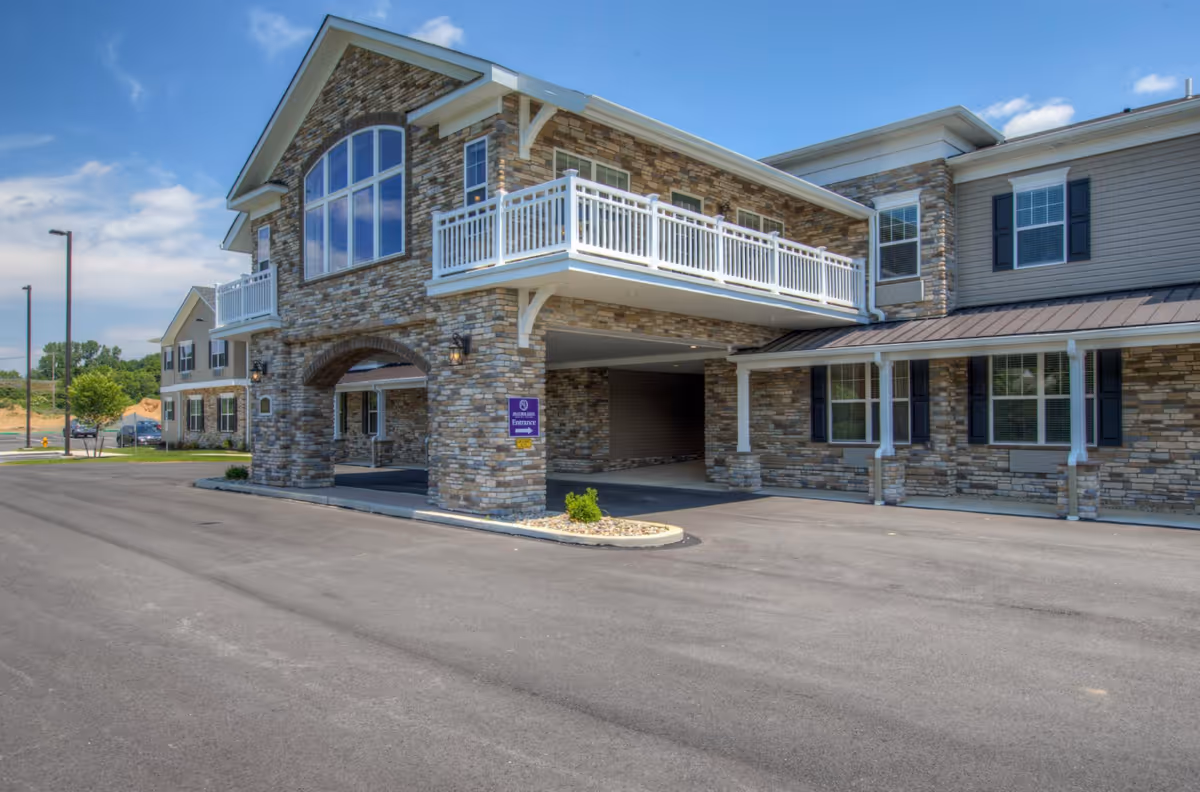Heather Glen Senior Living building exterior with stone facade and a wraparound balcony.