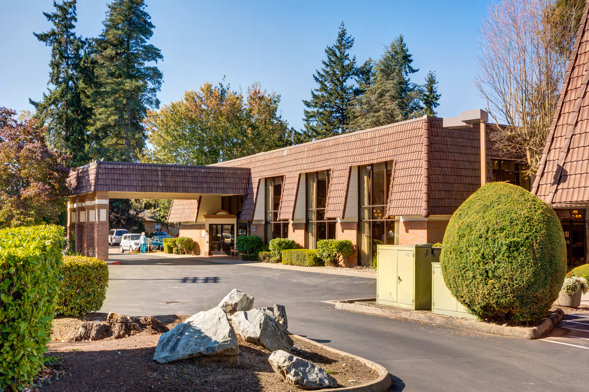 Exterior view of The Rivers at Puyallup building entrance with landscaped surroundings.