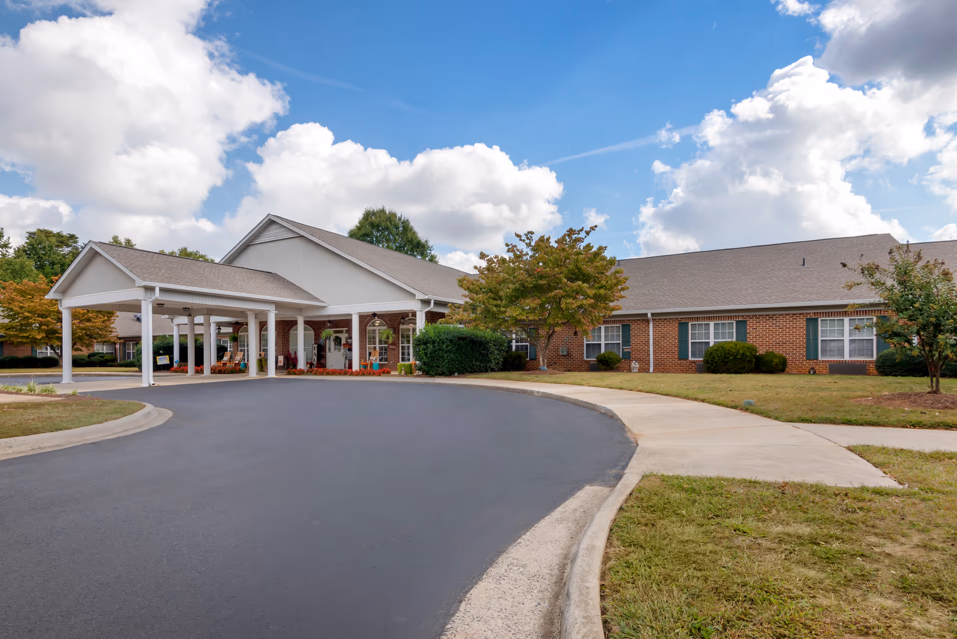 Exterior view of Brookdale Robinwood with curved driveway and covered entrance.