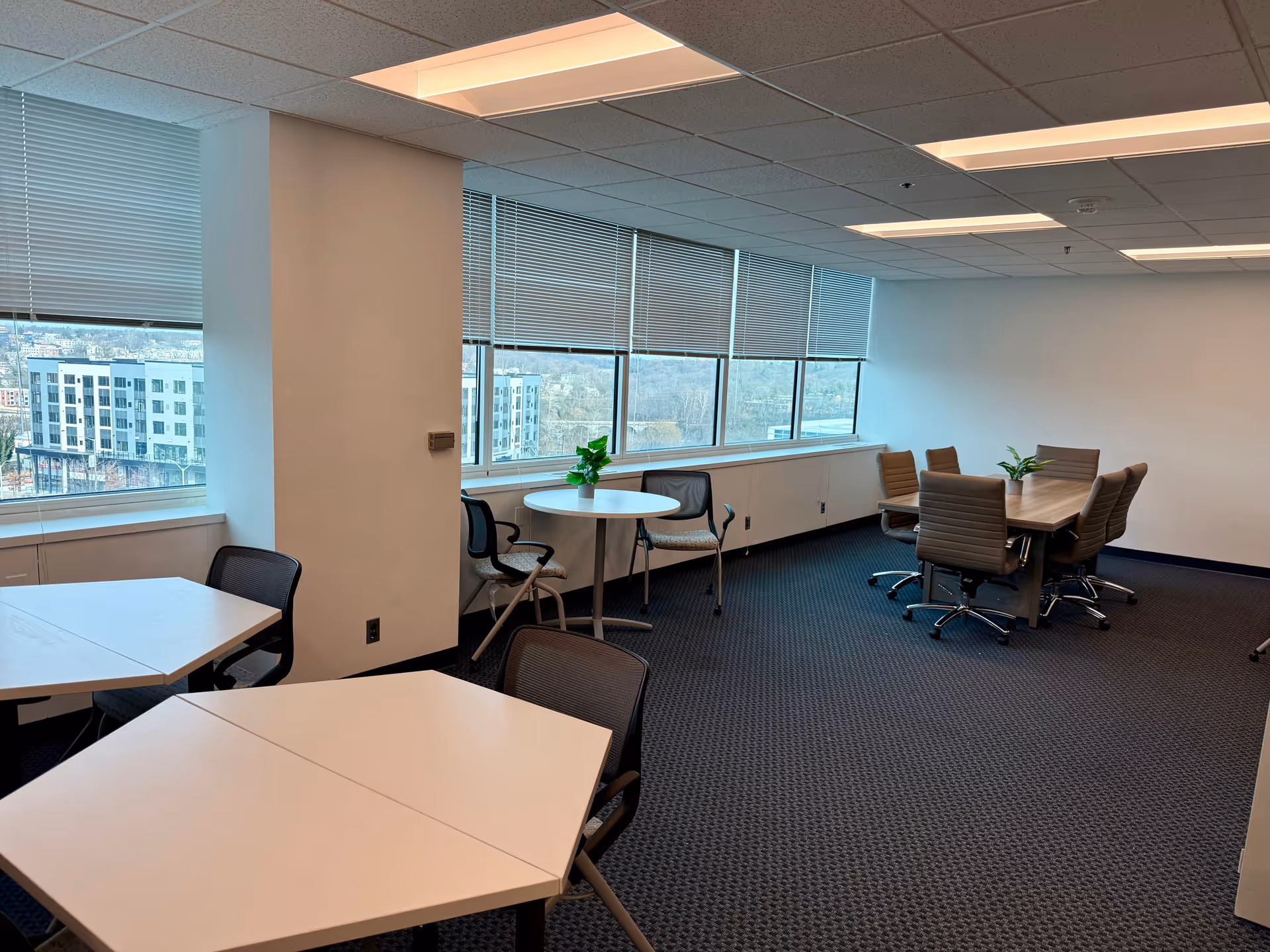 Spacious interior meeting area with tables, chairs, and large windows.
