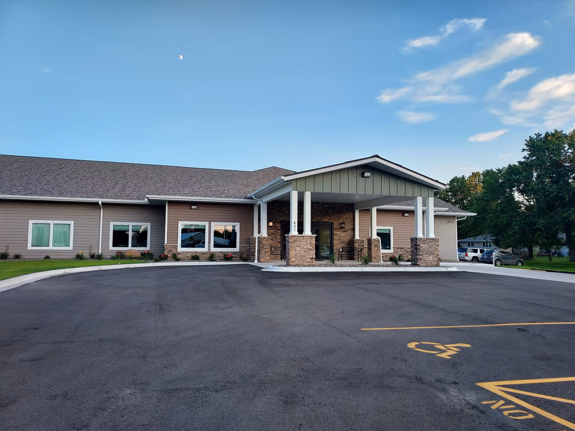 Front exterior of a single-story facility with a covered entrance and parking lot.