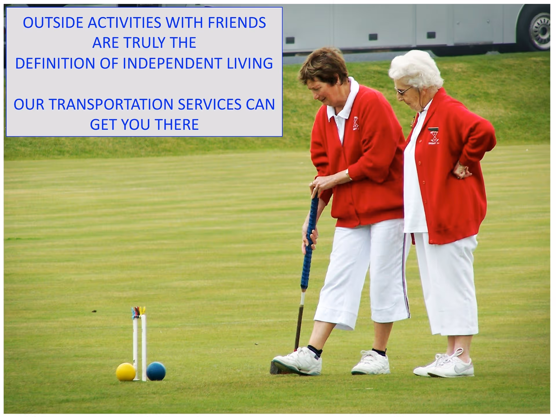 Two elderly women in red jackets play croquet on a green outdoor lawn.