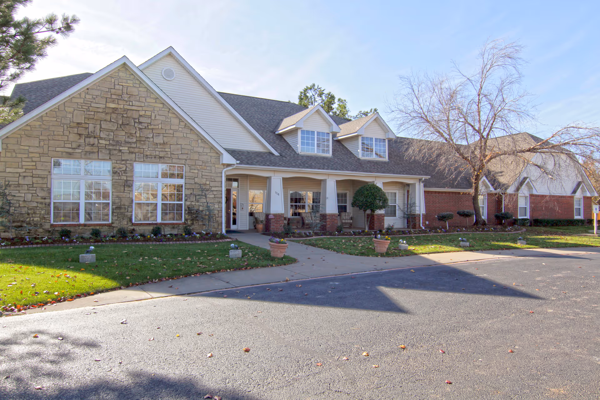 Front view of a single-story senior living center with stone and brick facade.