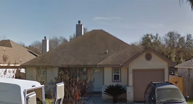 Front view of a single-story home-style facility with vehicles in the driveway.