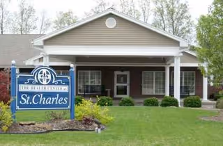 Front view of a senior living facility with a blue St. Charles sign and entrance.