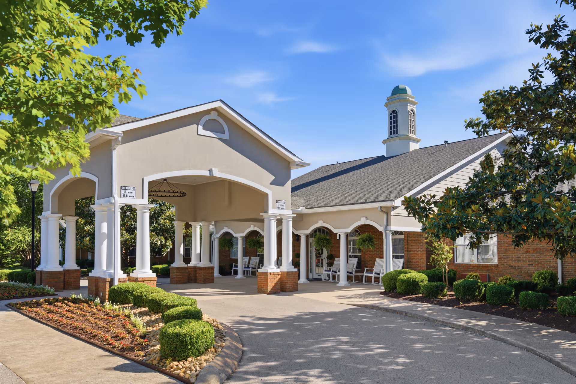 Front exterior of Charter Senior Living of Hermitage with a covered entrance and landscaping.