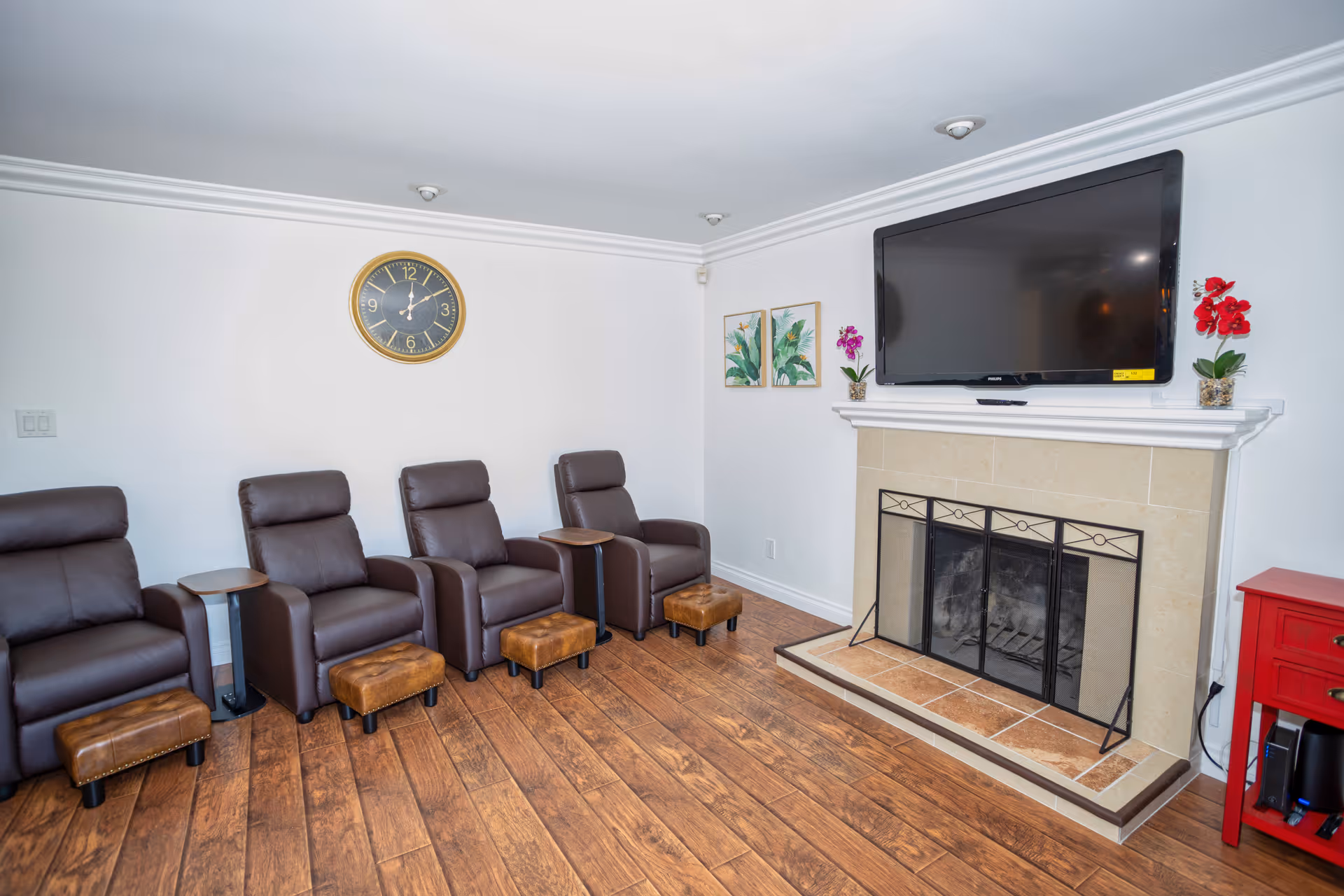 Lounge area with multiple recliner chairs, a fireplace, and a wall-mounted television.