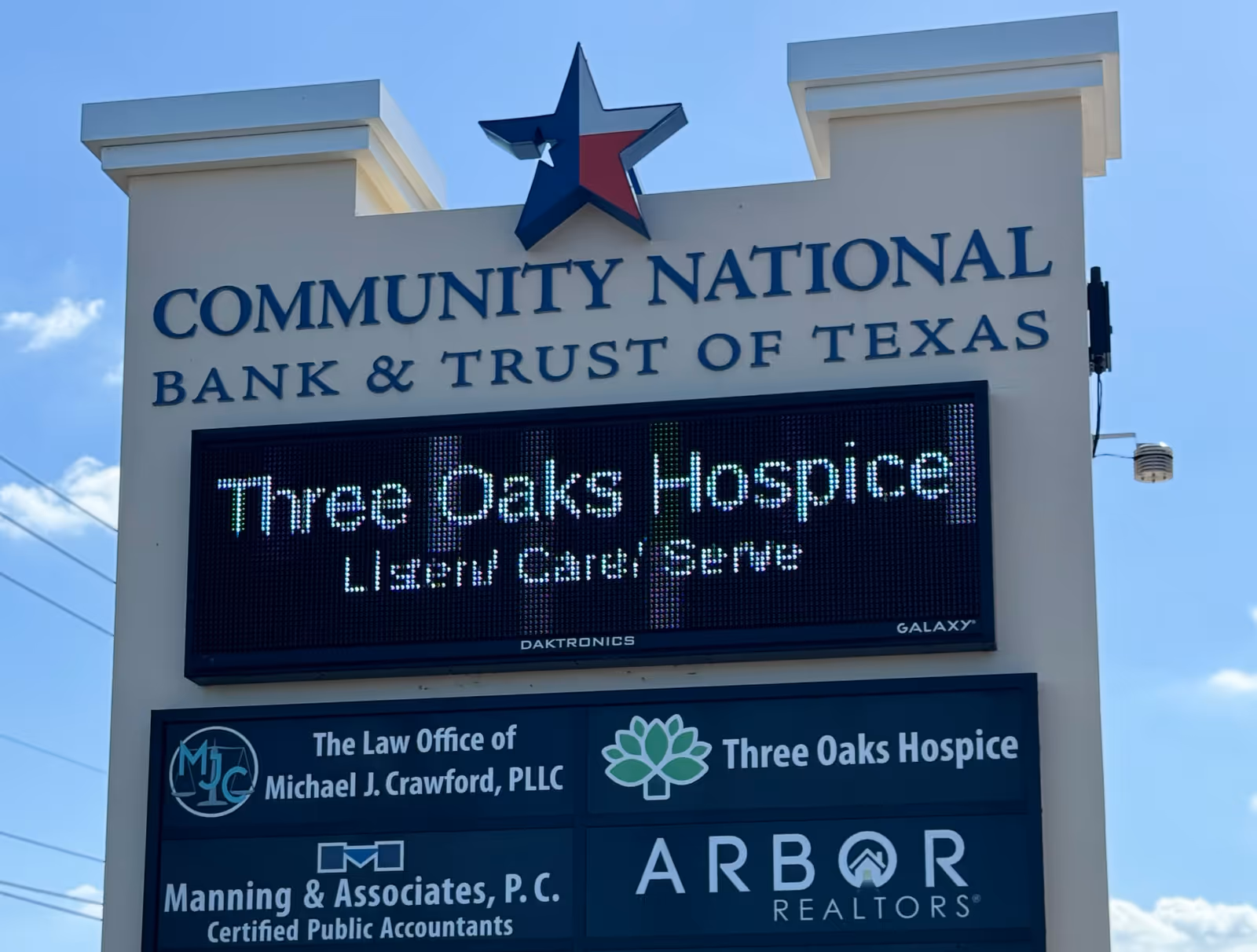 Outdoor sign structure featuring the bank sign and an LED display for Three Oaks Hospice.