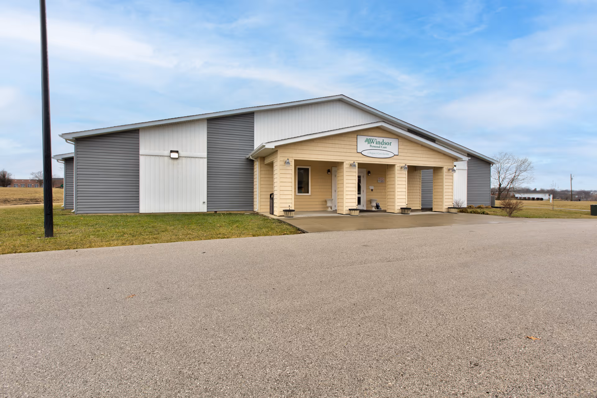 Front exterior of the Windsor Personal Care building with a covered entrance and adjacent parking area.