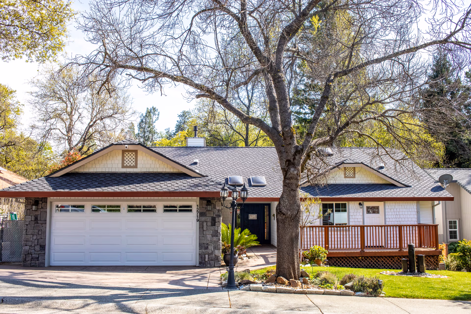 Single-story senior living facility exterior with garage, stone accents, and front porch.