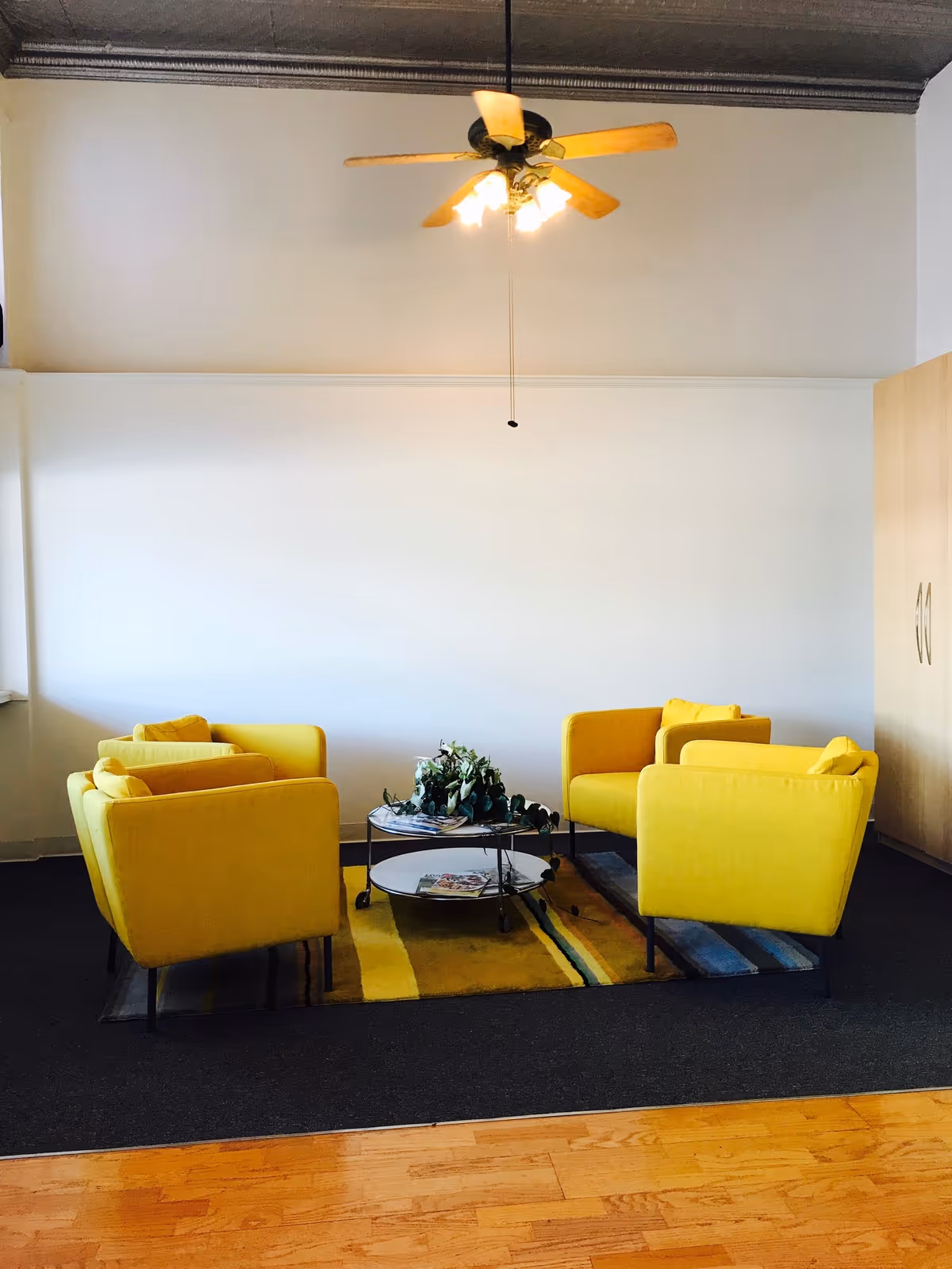 Bright yellow chairs surround a coffee table in a modern living area.