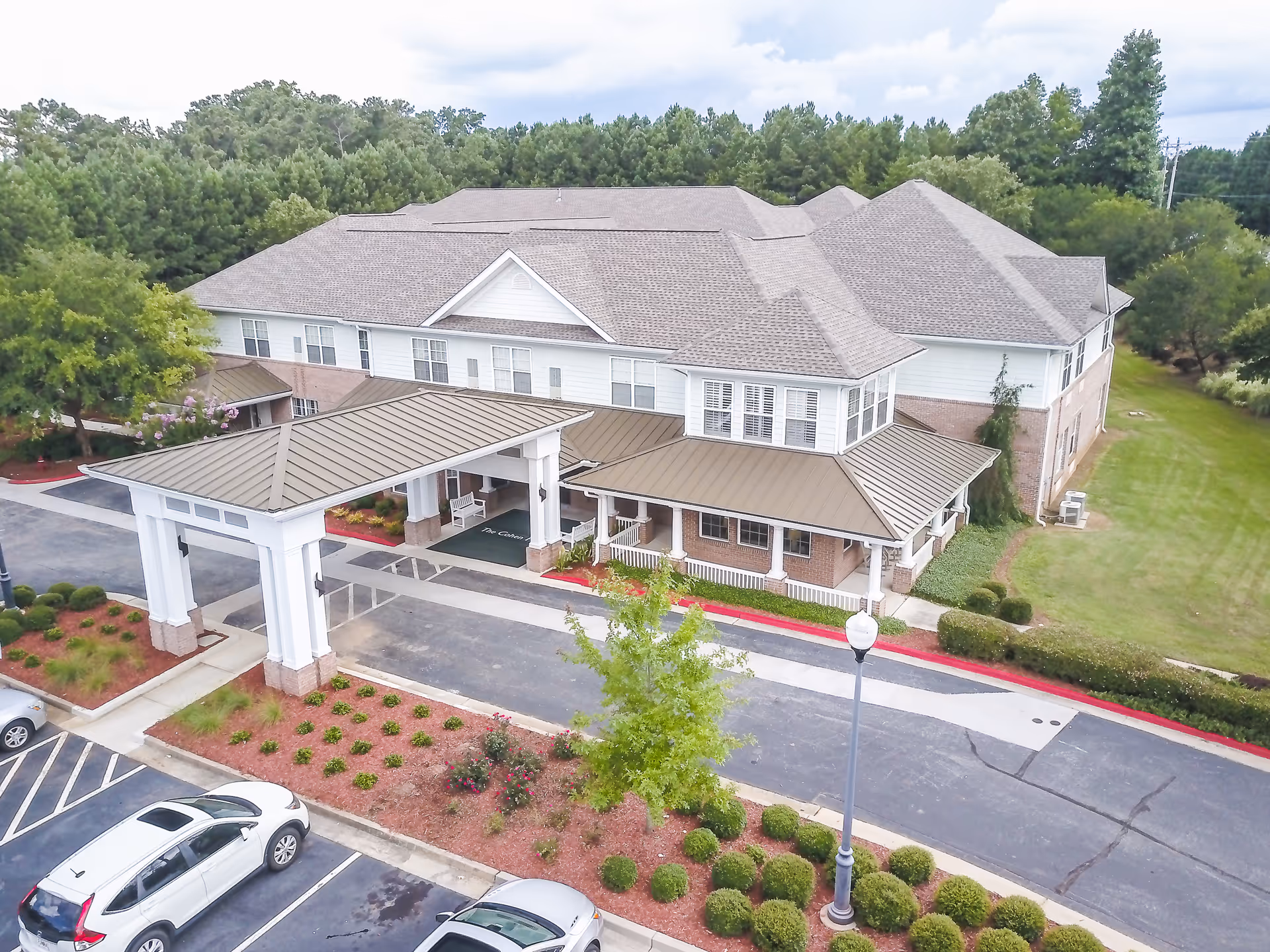 Aerial view of The Cohen Home senior living facility exterior with entrance canopy and parking.