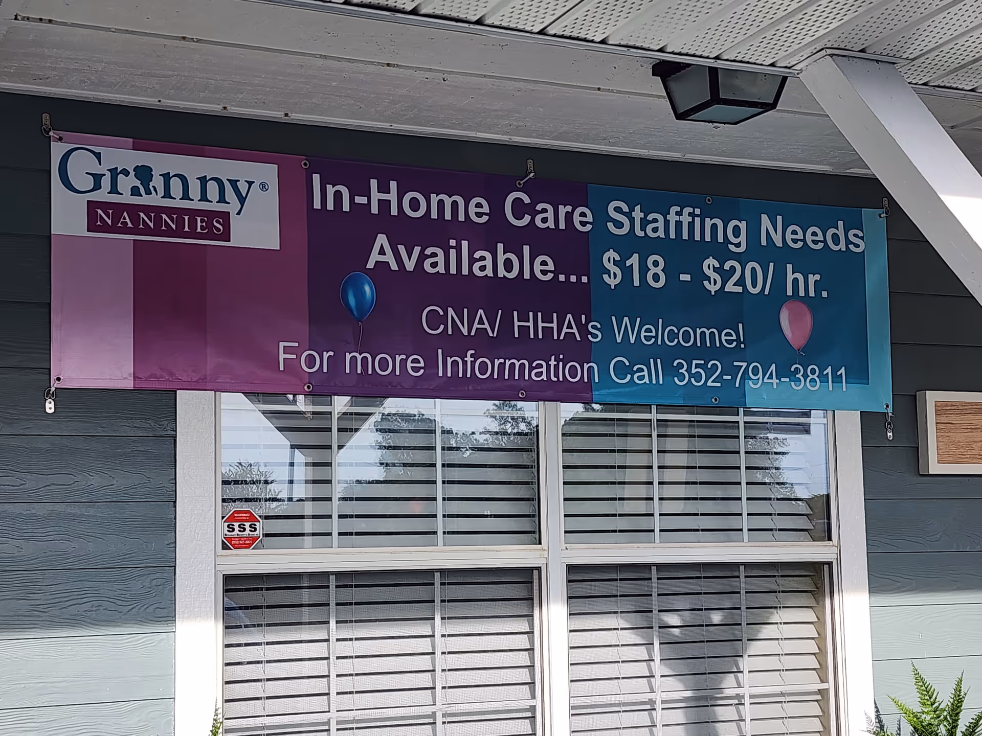 Exterior of a facility with a large banner for Granny Nannies in home care.