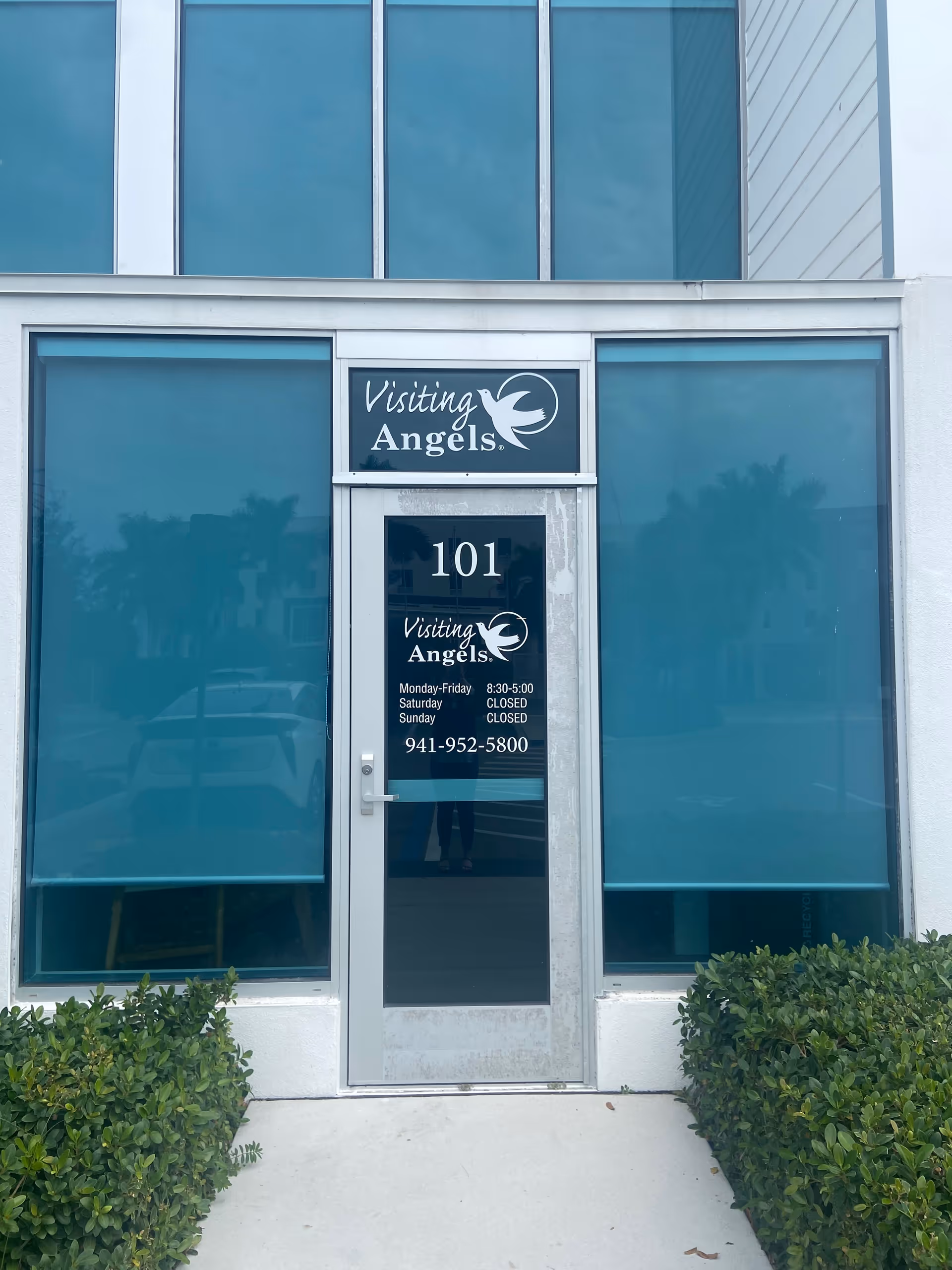 Exterior view of Visiting Angels Sarasota entrance with glass doors and blue-tinted windows.