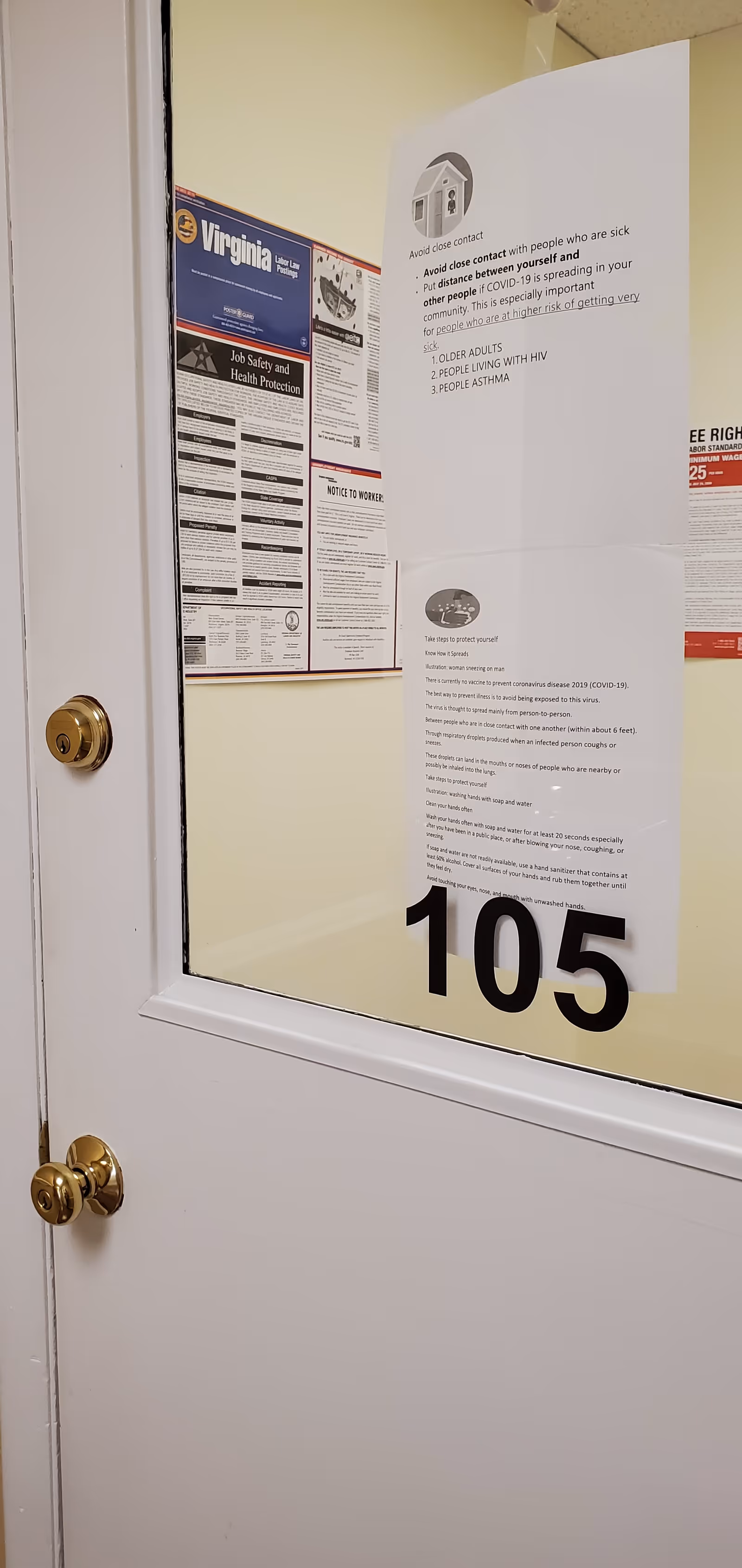 Interior doorway with 105 sign and posted notices in a hallway.