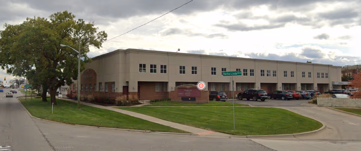 Exterior view of a medical center building with a curved driveway and parking.