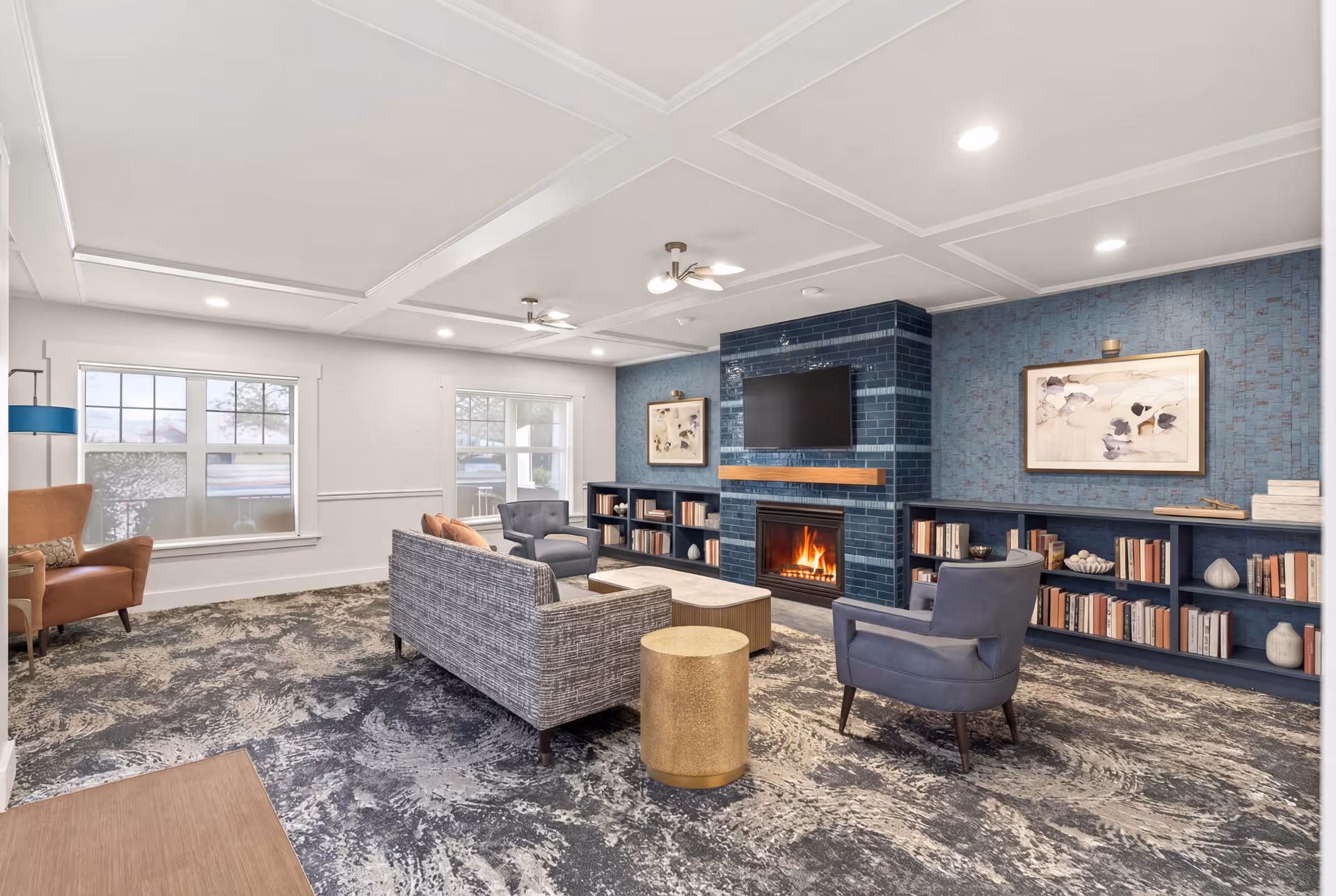 Cozy modern living room with a fireplace, blue accent wall, and built-in bookshelves.
