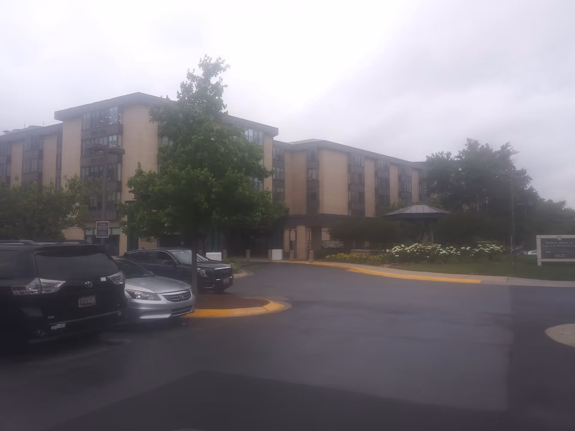 Exterior view of a multi-story senior living facility with a parking lot.
