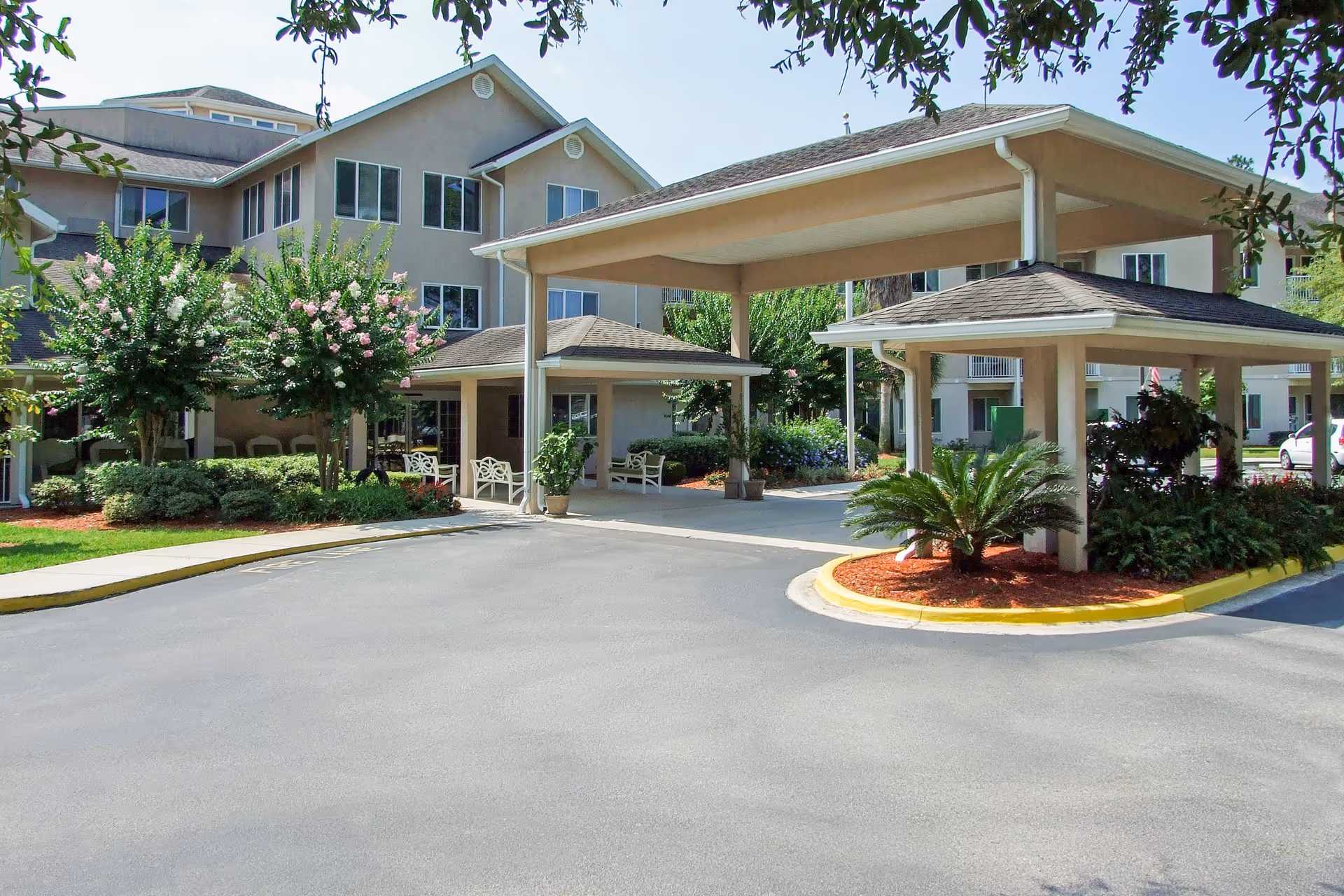 Exterior view of Augustine Landing entrance with covered drop-off and landscaped surroundings.
