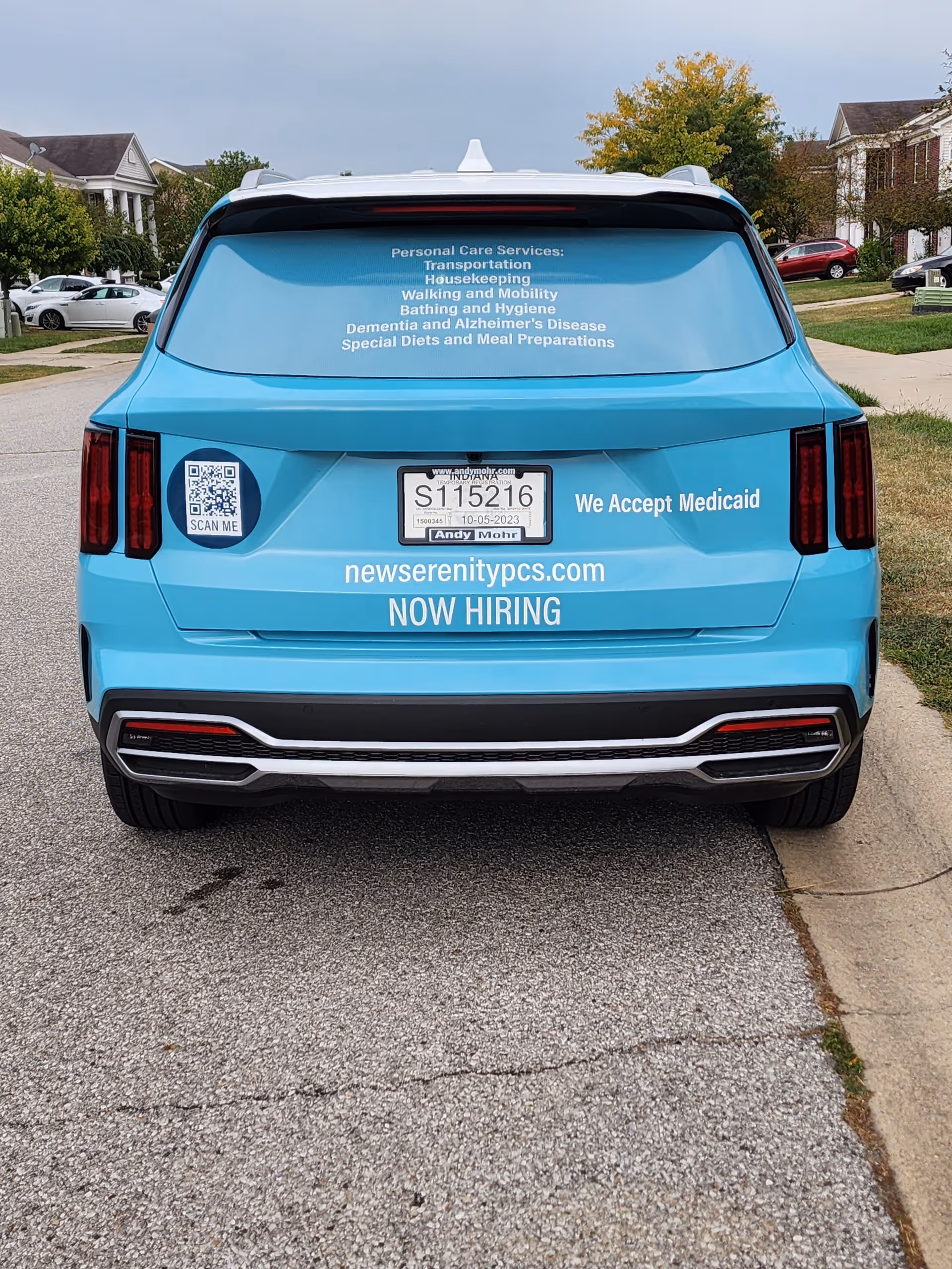 Blue promotional van for New Serenity Personal Care Services parked on a residential street.