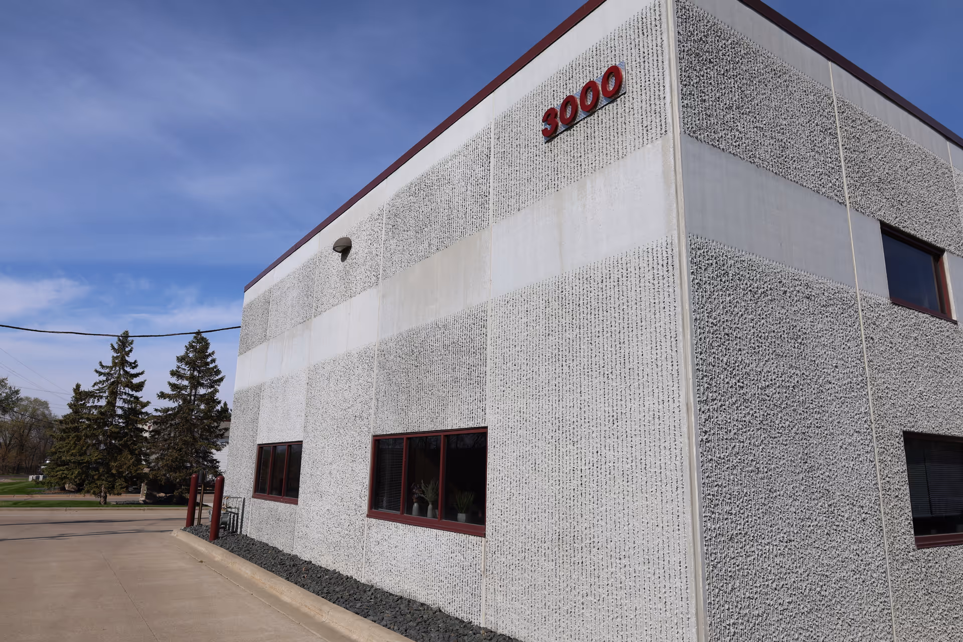 Exterior view of Deeku Healthcare building with textured walls and red-framed windows.