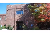 Brick RidgeView Assisted Living building exterior with trees and an American flag.