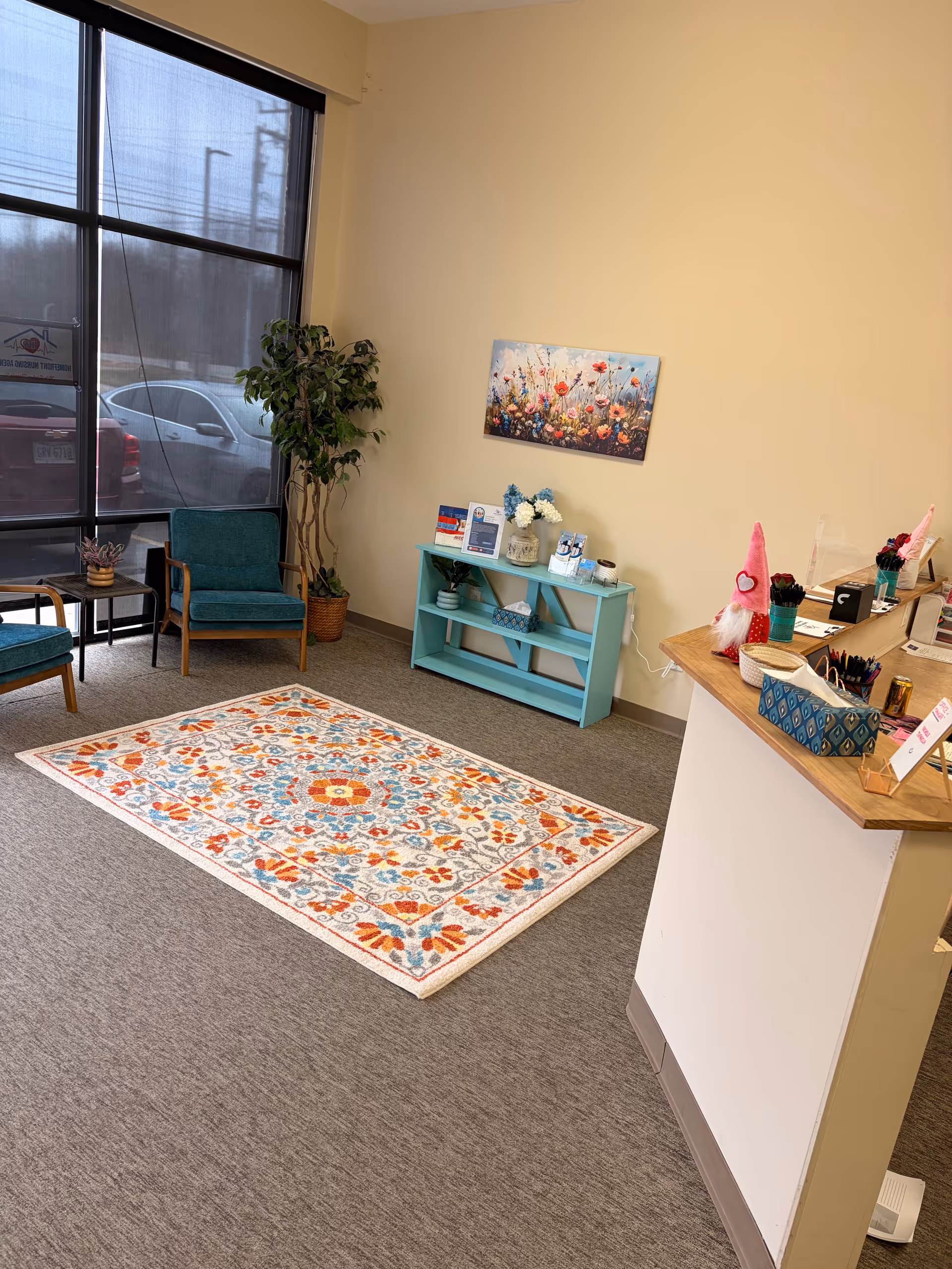 Bright lobby area with colorful rug, chairs, and a reception desk.