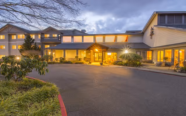 Exterior view of Stallworth Adult Foster Care with lit entrance and landscaping.