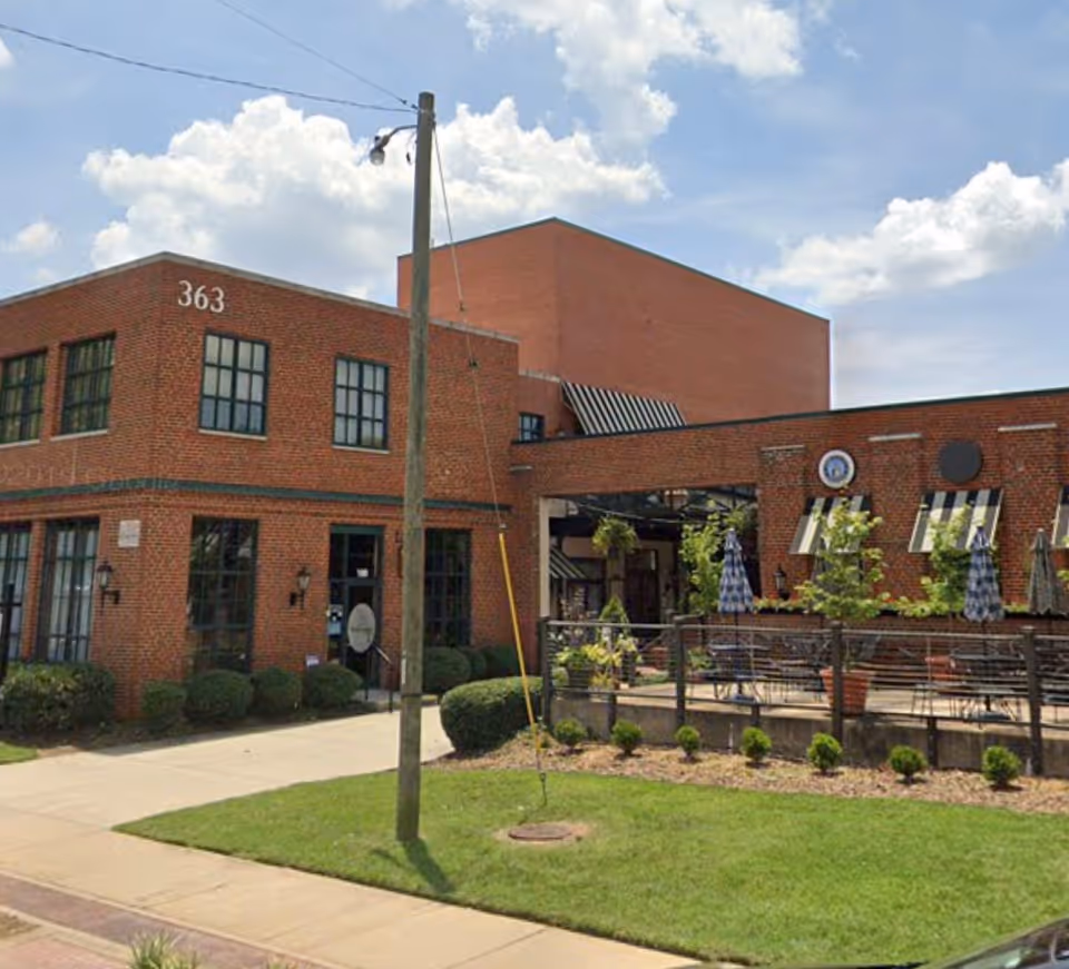 Brick senior care facility exterior with an outdoor patio and seating area
